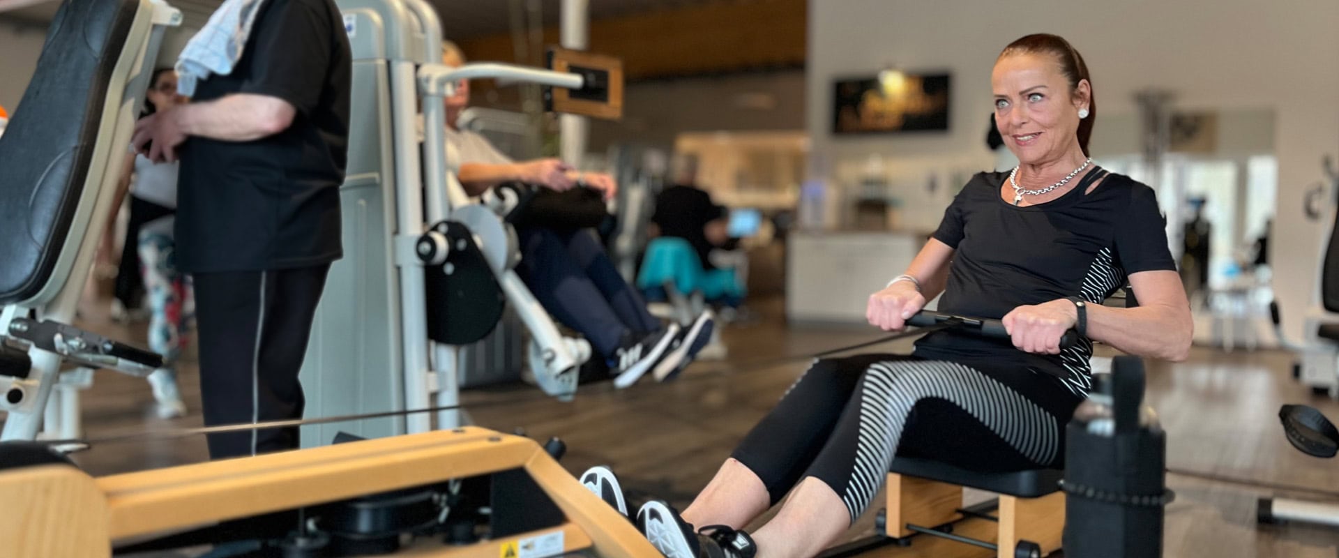 Eine Frau trainiert an einem Rudergerät im Fitnessstudio in Hahnstätten.